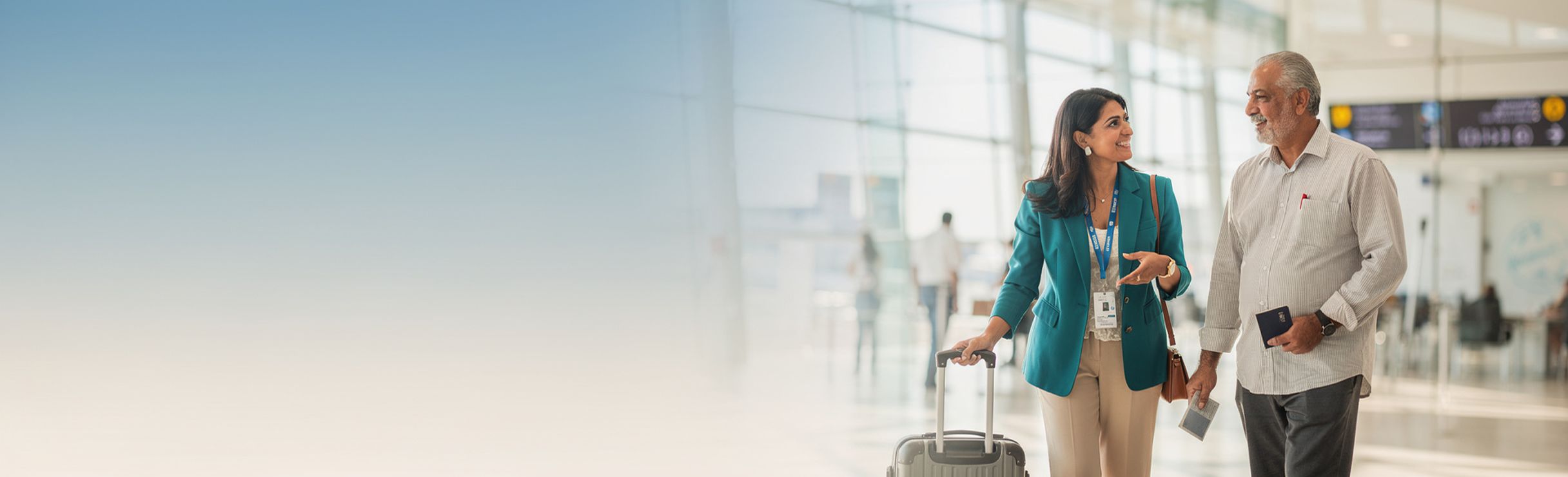 A care coordinator guiding a patient with a passport and suitcase through a modern terminal